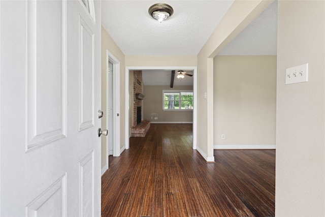 27093 Frye Rd, Splendora, TX 77372 - foyer featuring a fireplace, hardwood / wood-style flooring, ceiling fan, and a textured ceiling