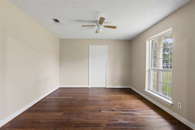 27093 Frye Rd, Splendora, TX 77372 - empty room with healthy amount of natural light, dark wood-type flooring, a ceiling fan, and a textured ceiling