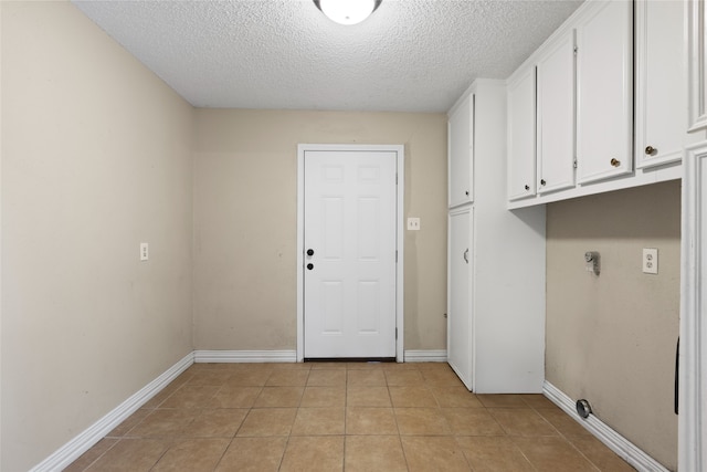 27093 Frye Rd, Splendora, TX 77372 - laundry area featuring cabinet space, a textured ceiling, and light tile patterned flooring