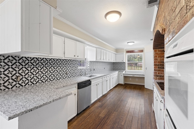 27093 Frye Rd, Splendora, TX 77372 - kitchen with white oven, dark wood-style floors, dishwasher, white cabinetry, and crown molding