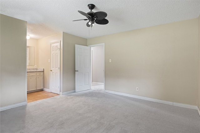 27093 Frye Rd, Splendora, TX 77372 - unfurnished bedroom with light carpet, a textured ceiling, ensuite bathroom, and ceiling fan