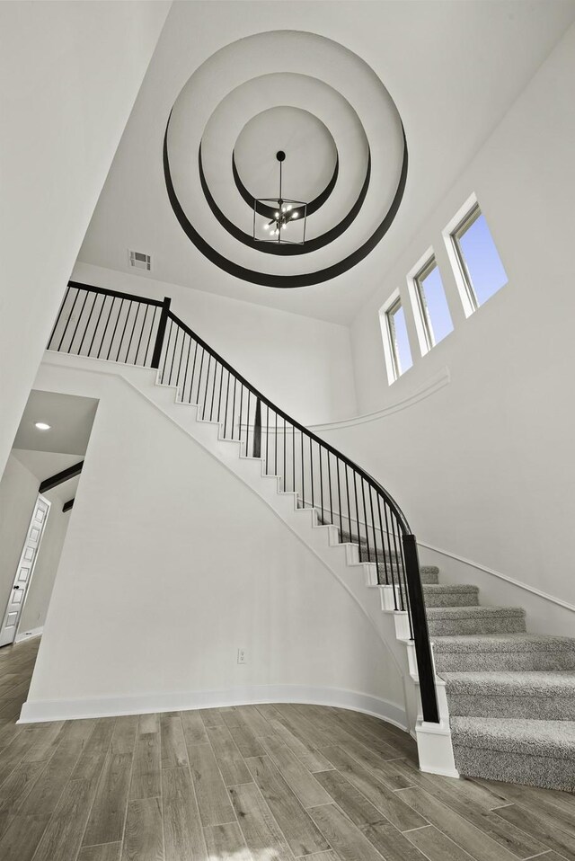 16710 Yaklin Meadow Ct, Humble, TX 77346 - stairs with a towering ceiling, a chandelier, and wood finished floors