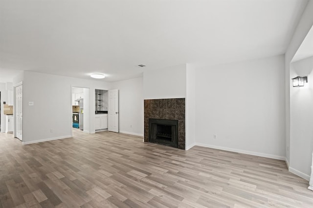 9901 Sharpcrest St Unit K-3, Houston, TX 77036 - unfurnished living room with light wood-style floors and a tile fireplace