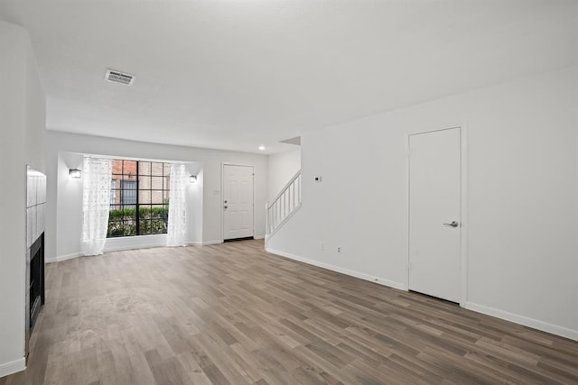 9901 Sharpcrest St Unit K-3, Houston, TX 77036 - unfurnished living room with stairs, wood finished floors, and a fireplace