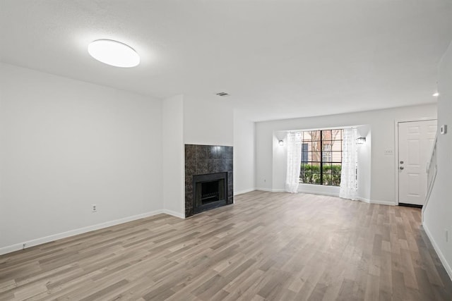 9901 Sharpcrest St Unit K-3, Houston, TX 77036 - unfurnished living room with light wood-style floors and a tiled fireplace