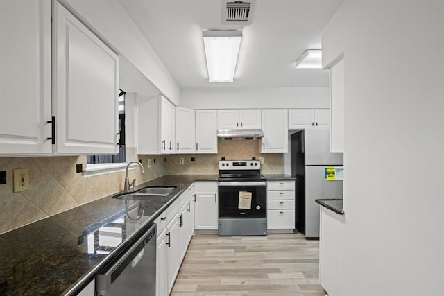 9901 Sharpcrest St Unit K-3, Houston, TX 77036 - kitchen featuring appliances with stainless steel finishes, white cabinets, light wood-style floors, and backsplash