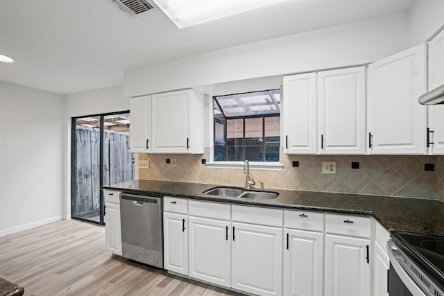 9901 Sharpcrest St Unit K-3, Houston, TX 77036 - kitchen featuring stainless steel appliances, decorative backsplash, light wood finished floors, and white cabinets