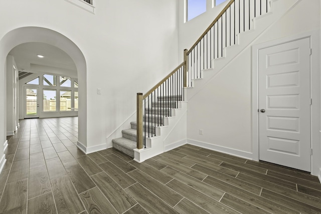 16738 Yaklin Meadow Ct, Humble, TX 77346 - foyer featuring arched walkways, wood finish floors, healthy amount of natural light, stairs, and a towering ceiling