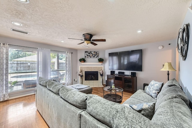 16307 Mango Ridge Ct, Humble, TX 77396 - living area featuring a ceiling fan, wood finished floors, a textured ceiling, recessed lighting, and a fireplace