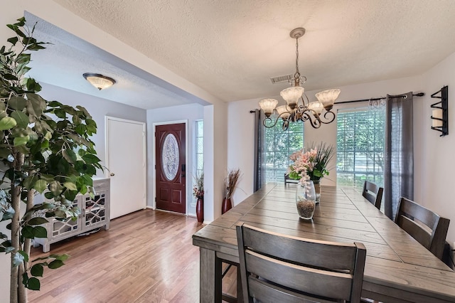 16307 Mango Ridge Ct, Humble, TX 77396 - dining area with a textured ceiling, a chandelier, and wood finished floors