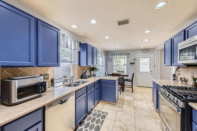 16307 Mango Ridge Ct, Humble, TX 77396 - kitchen featuring appliances with stainless steel finishes, recessed lighting, backsplash, blue cabinetry, and a textured ceiling