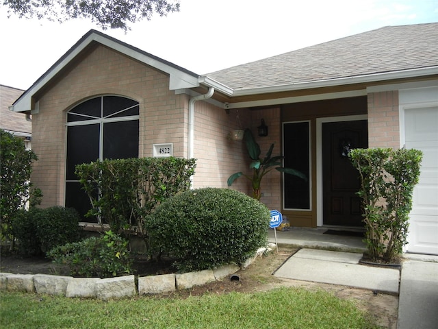 4822 Edgegate Dr, Spring, TX 77373 - property entrance with brick siding, roof with shingles, and an attached garage