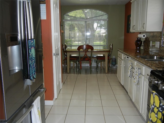 4822 Edgegate Dr, Spring, TX 77373 - kitchen featuring fridge with ice dispenser, light tile patterned flooring, dark stone countertops, white cabinetry, and gas stove