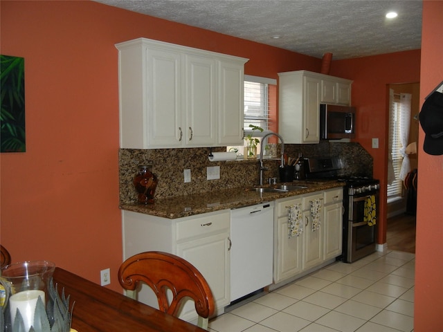 4822 Edgegate Dr, Spring, TX 77373 - kitchen with appliances with stainless steel finishes, backsplash, white cabinetry, dark stone counters, and a textured ceiling