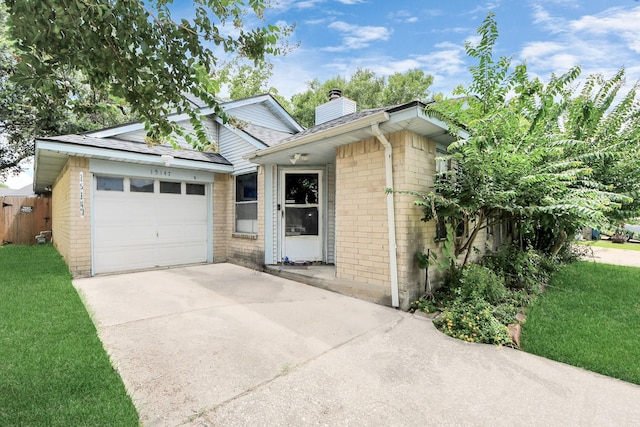 15147 Sheffield Ter, Channelview, TX 77530 - view of front of house with concrete driveway, brick siding, a garage, and a chimney