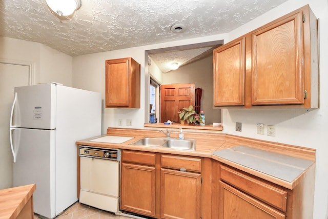 15147 Sheffield Ter, Channelview, TX 77530 - kitchen featuring white appliances, light countertops, a textured ceiling, light tile patterned flooring, and brown cabinetry