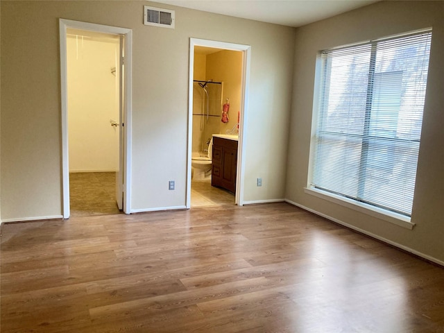 6602 Harbor Town Dr Unit 1008, Houston, TX 77036 - unfurnished bedroom with a walk in closet, light wood-type flooring, and connected bathroom