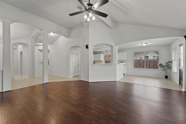 21327 Hadrian Dr, Katy, TX 77449 - unfurnished living room featuring vaulted ceiling, a ceiling fan, light wood-style floors, and arched walkways
