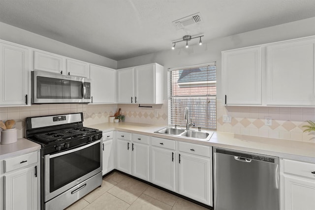 21327 Hadrian Dr, Katy, TX 77449 - kitchen with stainless steel appliances, white cabinets, light tile patterned floors, light countertops, and a textured ceiling