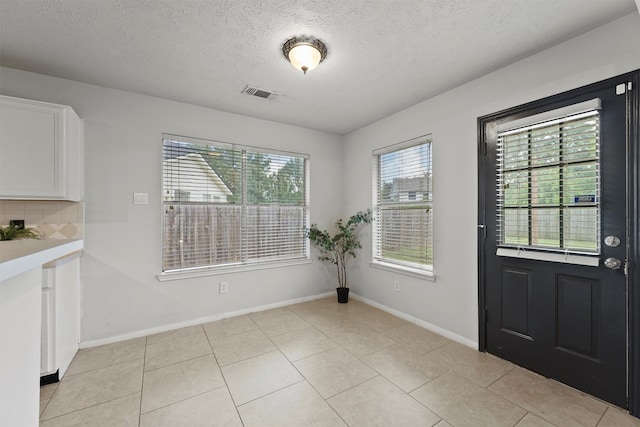 21327 Hadrian Dr, Katy, TX 77449 - unfurnished dining area with a textured ceiling and light tile patterned flooring