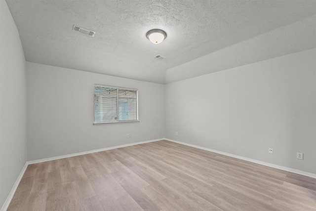 21327 Hadrian Dr, Katy, TX 77449 - empty room with light wood finished floors, a textured ceiling, and lofted ceiling