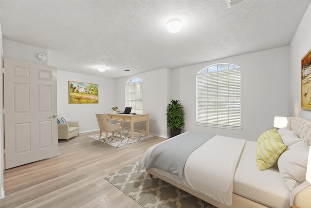 21327 Hadrian Dr, Katy, TX 77449 - bedroom featuring a textured ceiling, multiple windows, light wood-style floors, and an office area