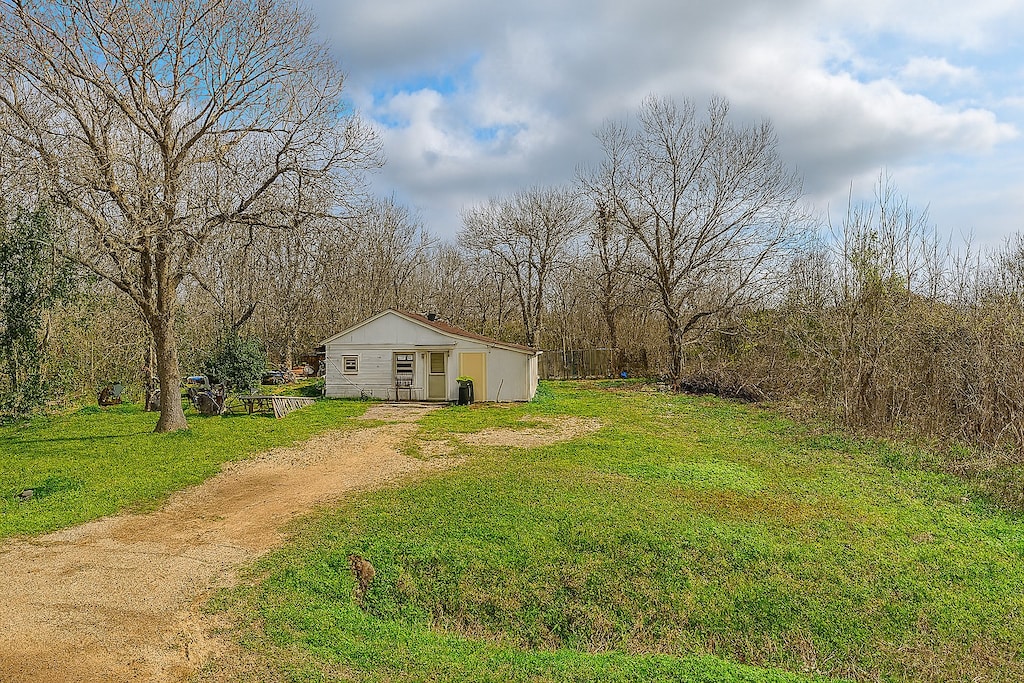 11805 S Garden St, Houston, TX 77071 - view of grassy yard with driveway and an outbuilding