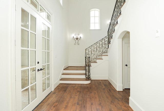764 Kuhlman Rd, Hunters Creek Village, TX 77024 - foyer featuring french doors, arched walkways, stairway, and dark wood-style flooring