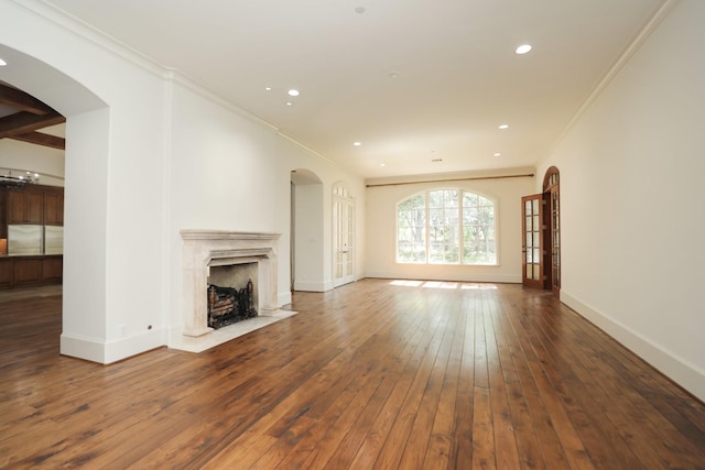 764 Kuhlman Rd, Hunters Creek Village, TX 77024 - unfurnished living room featuring arched walkways, hardwood / wood-style floors, a high end fireplace, ornamental molding, and recessed lighting