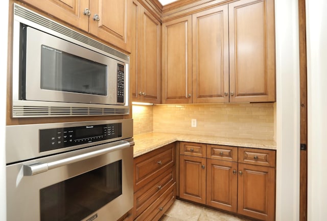 764 Kuhlman Rd, Hunters Creek Village, TX 77024 - kitchen with stainless steel appliances, backsplash, light stone countertops, and light tile patterned floors