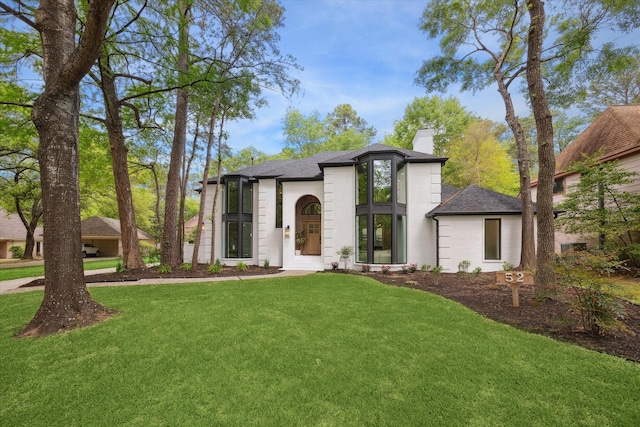52 Indian Clover, The Woodlands, TX 77381 - french country inspired facade with a chimney, a front yard, and roof with shingles