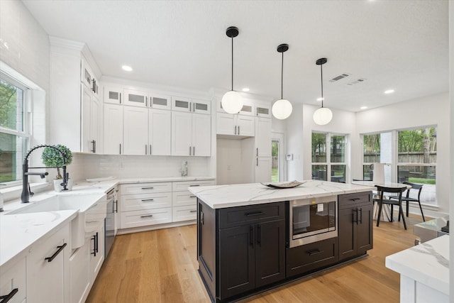 52 Indian Clover, The Woodlands, TX 77381 - kitchen with white cabinetry, appliances with stainless steel finishes, decorative light fixtures, glass insert cabinets, and recessed lighting
