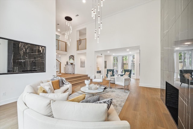 52 Indian Clover, The Woodlands, TX 77381 - living area featuring ornamental molding, wood finished floors, a high ceiling, and stairs