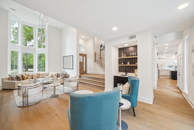 52 Indian Clover, The Woodlands, TX 77381 - living room featuring stairway, light wood-style floors, recessed lighting, and a towering ceiling