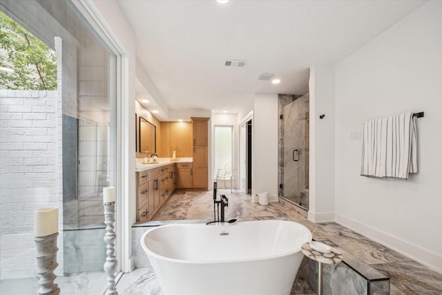 52 Indian Clover, The Woodlands, TX 77381 - bathroom with marble tiled floors, vanity, a freestanding tub, a shower stall, and recessed lighting