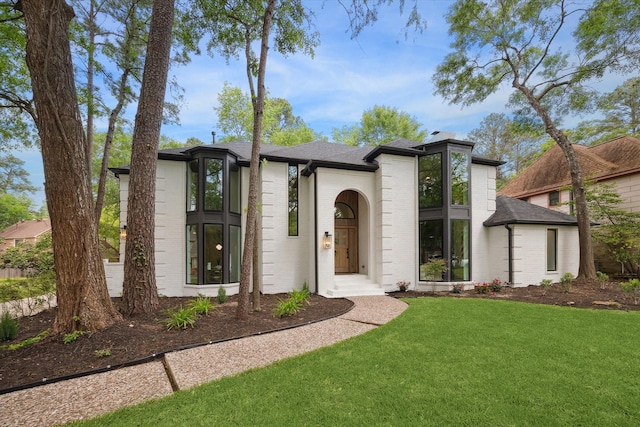 52 Indian Clover, The Woodlands, TX 77381 - view of front of property with brick siding, a chimney, a front lawn, and roof with shingles