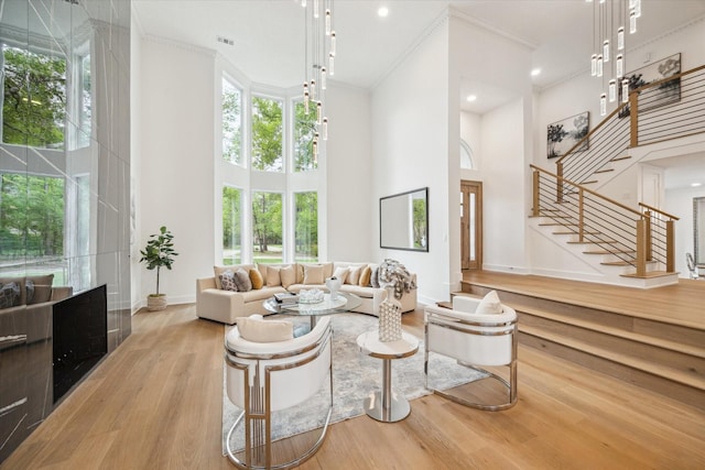 52 Indian Clover, The Woodlands, TX 77381 - living area featuring a towering ceiling, wood finished floors, stairway, ornamental molding, and recessed lighting