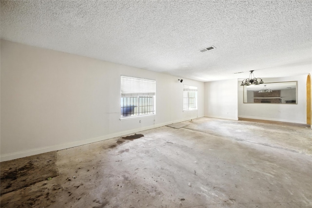 3819 Galway Ln, Houston, TX 77080 - unfurnished room featuring unfinished concrete flooring, a textured ceiling, and a chandelier