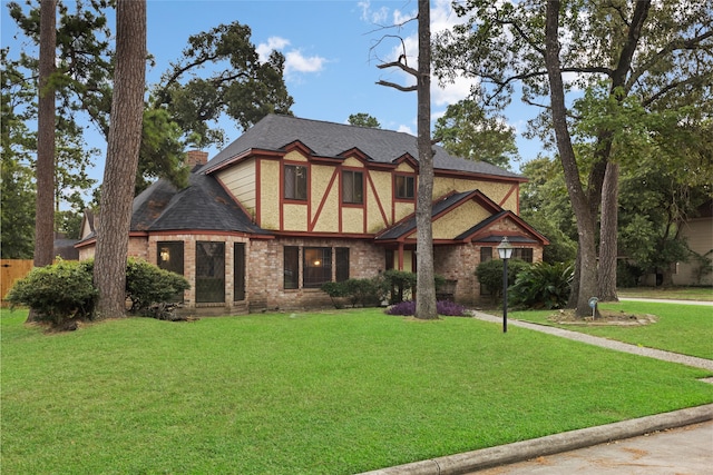 727 Baltic Ln, Houston, TX 77090 - tudor house featuring brick siding, roof with shingles, and a chimney