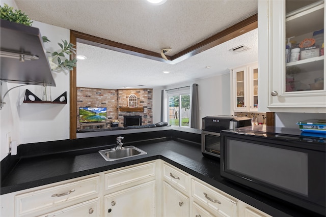 727 Baltic Ln, Houston, TX 77090 - kitchen featuring a textured ceiling, dark countertops, white cabinetry, glass insert cabinets, and open floor plan