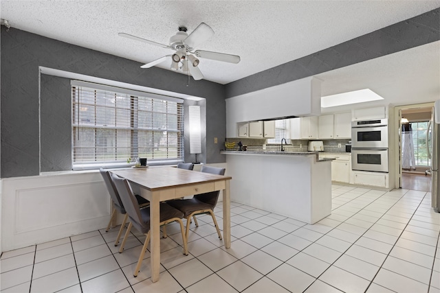 727 Baltic Ln, Houston, TX 77090 - dining area with plenty of natural light, a textured ceiling, light tile patterned floors, and a ceiling fan