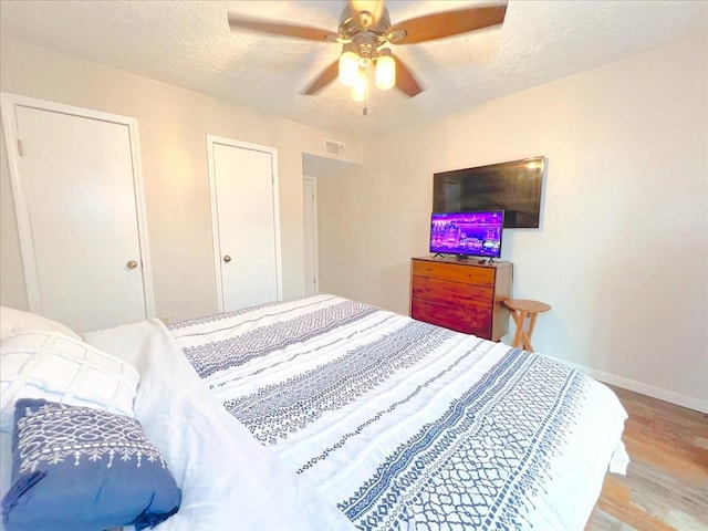 6305 Westward St Unit 106, Houston, TX 77081 - bedroom with wood finished floors, a textured ceiling, and ceiling fan