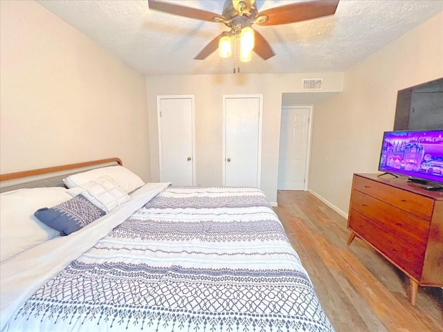 6305 Westward St Unit 106, Houston, TX 77081 - bedroom with light wood-style floors, a textured ceiling, and a ceiling fan