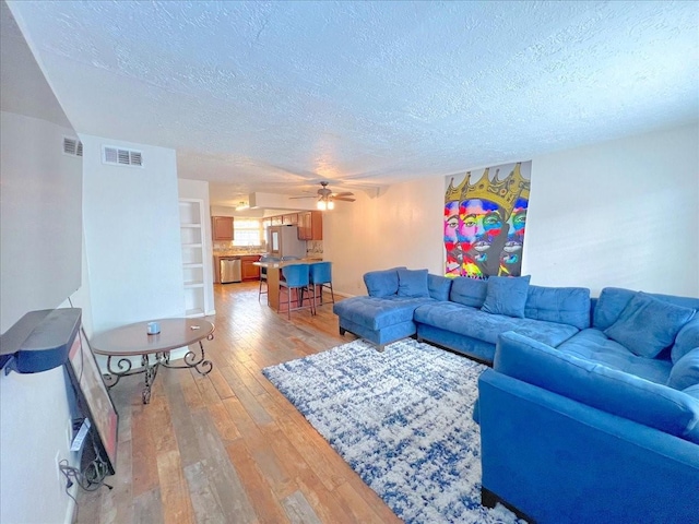 6305 Westward St Unit 106, Houston, TX 77081 - living room with a textured ceiling, light wood finished floors, and ceiling fan