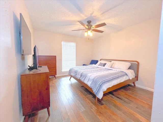 6305 Westward St Unit 106, Houston, TX 77081 - bedroom with light wood-style floors, a textured ceiling, and ceiling fan