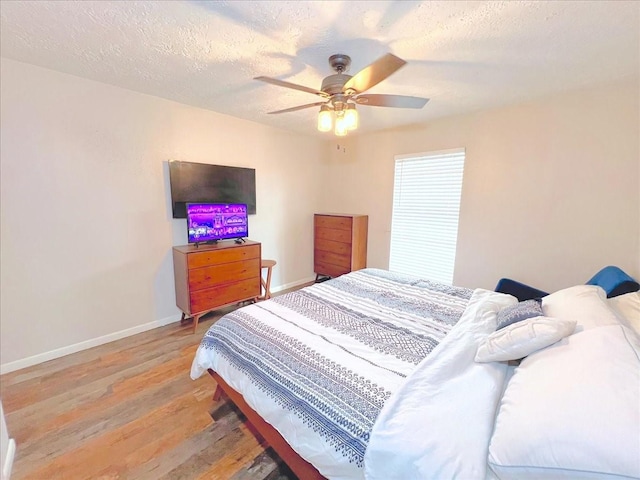 6305 Westward St Unit 106, Houston, TX 77081 - bedroom featuring light wood finished floors, a ceiling fan, and a textured ceiling