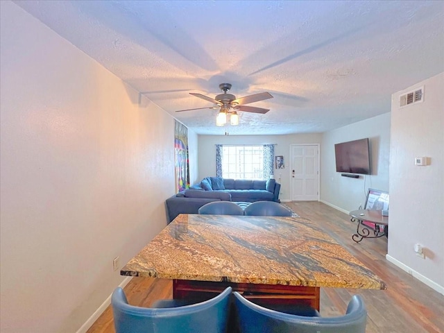 6305 Westward St Unit 106, Houston, TX 77081 - dining room with wood finished floors, a ceiling fan, and a textured ceiling