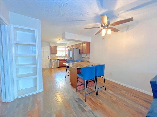 6305 Westward St Unit 106, Houston, TX 77081 - dining space featuring light wood-type flooring, a ceiling fan, and a textured ceiling