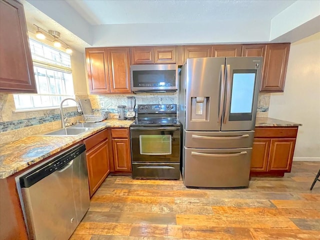 6305 Westward St Unit 106, Houston, TX 77081 - kitchen with stainless steel appliances, backsplash, brown cabinets, and light stone countertops