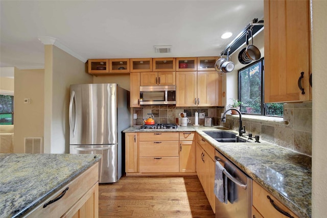 10 Featherfall Pl, Spring, TX 77381 - kitchen with appliances with stainless steel finishes, light wood finished floors, light stone countertops, decorative backsplash, and crown molding